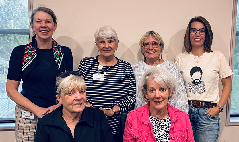 A group of women standing together smiling A group of women standing together smiling
