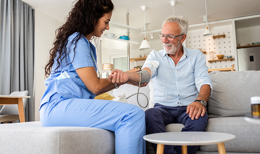 district nurse at clients home taking blood pressure